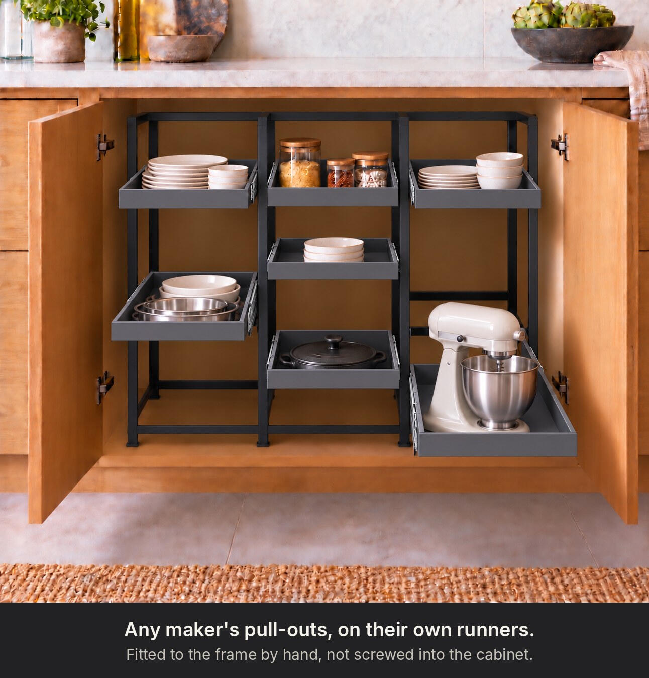 The same frame in use, holding cast iron cookware on pull out shelves